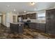 A modern kitchen is spacious and features an island, stainless steel appliances, and wood-look flooring at 5601 W Missouri Ave # 150, Glendale, AZ 85301