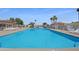 Community pool featuring lounge chairs, tiled roof cabana, and beautiful blue water on a sunny day at 5601 W Missouri Ave # 150, Glendale, AZ 85301