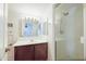 Bright bathroom with a single vanity, large mirror, and a walk-in shower with glass doors at 5749 S 21St Ter, Phoenix, AZ 85040