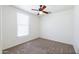 Well-lit bedroom featuring carpet, white walls, ceiling fan and window with blinds at 5749 S 21St Ter, Phoenix, AZ 85040