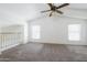 Spacious bedroom with neutral carpet, a ceiling fan, a window with blinds and a view of the loft at 5749 S 21St Ter, Phoenix, AZ 85040