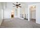 Spacious main bedroom with neutral carpet, ceiling fan, walk-in closet, and a view of the bathroom at 5749 S 21St Ter, Phoenix, AZ 85040