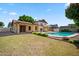 Backyard with lush green yard and pool for entertaining and relaxing at 608 E Arabian Ct, Gilbert, AZ 85296