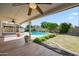 Backyard with lush green yard, pool, and covered patio for entertaining and relaxing at 608 E Arabian Ct, Gilbert, AZ 85296