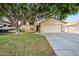 Charming home with a large tree shading the front yard and a two-car garage at 608 E Arabian Ct, Gilbert, AZ 85296