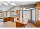 Bright kitchen featuring wood cabinets, tile floors, and a peninsula island providing extra counter space and seating at 608 E Arabian Ct, Gilbert, AZ 85296