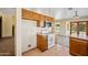 Cozy kitchen featuring wood cabinetry, white appliances, and view of backyard pool at 608 E Arabian Ct, Gilbert, AZ 85296