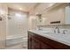 A spacious bathroom showcases a dual sink vanity, marble countertops, and a shower-tub combination at 8051 W Mariposa Dr, Phoenix, AZ 85033