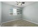 This cozy bedroom features a ceiling fan, sleek tile flooring, and minimalist floating shelves at 8051 W Mariposa Dr, Phoenix, AZ 85033