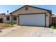 A single-story home with an attached garage, concrete driveway, and low maintenance yard with a small tree at 8051 W Mariposa Dr, Phoenix, AZ 85033
