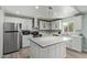 The remodeled kitchen features stainless steel appliances and a central island with counter seating at 8051 W Mariposa Dr, Phoenix, AZ 85033