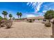 Spacious backyard featuring gravel landscaping, mature landscaping, palm trees, and a covered patio at 8103 E Dartmouth St, Mesa, AZ 85207