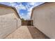Narrow side yard featuring gravel, a gate, and stucco walls on both sides of the property at 8103 E Dartmouth St, Mesa, AZ 85207