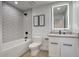 Modern bathroom with shower and tub combo with decorative tile surround, and a stylish vanity with lighted mirror at 8318 E Sells Dr, Scottsdale, AZ 85251