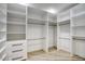 Spacious walk-in closet with white shelving and drawers, complete with hanging rods and wood floors at 8318 E Sells Dr, Scottsdale, AZ 85251