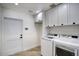 Clean laundry room with white cabinets and modern washer and dryer at 8318 E Sells Dr, Scottsdale, AZ 85251