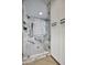 Luxurious walk-in shower with frameless glass door and marbled walls plus stainless steel fixtures and hardware at 8318 E Sells Dr, Scottsdale, AZ 85251