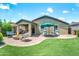 Charming backyard with green lawn, brick patio, and cozy seating around a fire pit at 907 E Kelsi Ave, San Tan Valley, AZ 85140