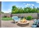 Private backyard with a fire pit, brick patio, green lawn, bench seating, and garden at 907 E Kelsi Ave, San Tan Valley, AZ 85140