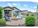 Relaxing backyard featuring a fire pit, brick patio, green lawn, and ample seating at 907 E Kelsi Ave, San Tan Valley, AZ 85140