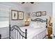 Cozy bedroom featuring an iron bed frame, soft bedding, and vintage décor creating a relaxing retreat at 907 E Kelsi Ave, San Tan Valley, AZ 85140