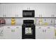 Well-lit kitchen with white cabinetry, black appliances, and decorative accents at 907 E Kelsi Ave, San Tan Valley, AZ 85140