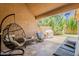 Covered patio seating area featuring a hanging swing chair and outdoor seating with a grill at 9196 E Evans Dr, Scottsdale, AZ 85260