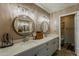 Bathroom with double vanity, wood cabinets, decorative lighting, and framed round mirrors at 9196 E Evans Dr, Scottsdale, AZ 85260