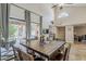 Bright dining room with high ceilings, a rustic wood table, and seamless access to the covered outdoor patio at 9196 E Evans Dr, Scottsdale, AZ 85260