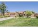 Charming single-story home featuring a terra cotta roof, lush green lawn, and a two-car garage at 9196 E Evans Dr, Scottsdale, AZ 85260