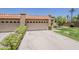 Beige home featuring 2-car garage with tile roof and well-maintained landscaping at 9196 E Evans Dr, Scottsdale, AZ 85260