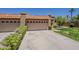 Inviting home featuring a three car garage, terra cotta roof, desert landscaping, and an expansive driveway at 9196 E Evans Dr, Scottsdale, AZ 85260