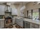 Modern kitchen featuring stainless appliances, quartz countertops, and a stylish range hood, open to the dining area at 9196 E Evans Dr, Scottsdale, AZ 85260