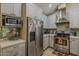 Bright kitchen with stainless steel appliances, tile backsplash, and custom cabinets for ample storage at 9196 E Evans Dr, Scottsdale, AZ 85260