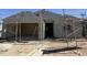 Exterior elevation of a home under construction, with scaffolding and raw materials visible, offering a glimpse of the building process at 9531 W Parkway Dr, Tolleson, AZ 85353