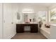 Bright bathroom featuring double sinks, a large mirror, and a soaking tub under a window at 9649 S 51 St St, Phoenix, AZ 85044