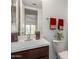 Cozy bathroom features a white sink, dark wood cabinets, decorative towels, and a white toilet at 9649 S 51 St St, Phoenix, AZ 85044