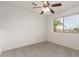 Neutral bedroom with plush carpeting, a ceiling fan, and a window overlooking the community at 9649 S 51 St St, Phoenix, AZ 85044