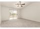 Large bedroom features plush carpeting, a ceiling fan, and sliding glass doors to a balcony at 9649 S 51 St St, Phoenix, AZ 85044