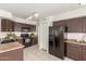 Charming kitchen with tile flooring, black appliances, dark wood cabinets, and modern refrigerator at 9649 S 51 St St, Phoenix, AZ 85044