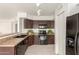 Well-lit kitchen features tile flooring, black appliances, dark wood cabinets, and a double basin sink at 9649 S 51 St St, Phoenix, AZ 85044