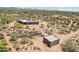Secluded estate featuring custom home, outbuildings, and natural desert landscaping with mountain views in the distance at 10600 E Cordova St, Gold Canyon, AZ 85118
