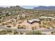 An aerial shows an estate-style home with additional building, native vegetation and mountain views at 10600 E Cordova St, Gold Canyon, AZ 85118