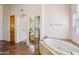 Spacious bathroom featuring tile floors, a soaking tub, and a wood door at 10600 E Cordova St, Gold Canyon, AZ 85118