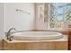 Bathroom featuring a luxurious bathtub set in tile surround with glass block window at 10600 E Cordova St, Gold Canyon, AZ 85118