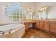Well-lit bathroom with a corner tub, block glass window, and vanity at 10600 E Cordova St, Gold Canyon, AZ 85118