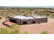 Aerial view of custom desert home showcasing large garage and stucco facade with red patio at 10600 E Cordova St, Gold Canyon, AZ 85118