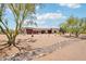 Southwestern-style home with circular driveway, mature trees, and desert landscape offering privacy and curb appeal at 10600 E Cordova St, Gold Canyon, AZ 85118