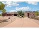 Southwestern-style home featuring a circular driveway, mature trees, and desert landscape at 10600 E Cordova St, Gold Canyon, AZ 85118