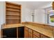 View of a wet bar with wooden cabinets, granite countertops, and a mini fridge at 10600 E Cordova St, Gold Canyon, AZ 85118